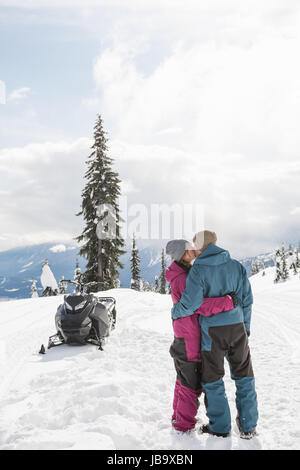 Paar küssen einander in verschneiten Alpen im winter Stockfoto