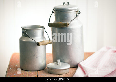 Vintage Milchkannen auf alten Holztisch Stockfoto