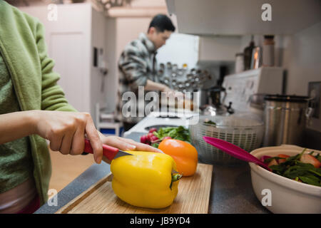 Mittleren Bereich der Frau Schneiden von Gemüse in der Küche zu Hause Stockfoto