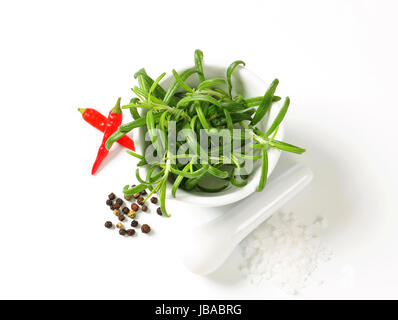 Stillleben mit frischem Rosmarin in einem Mörser, Pfefferkörner, Meer Salz und rote Chilischoten Stockfoto