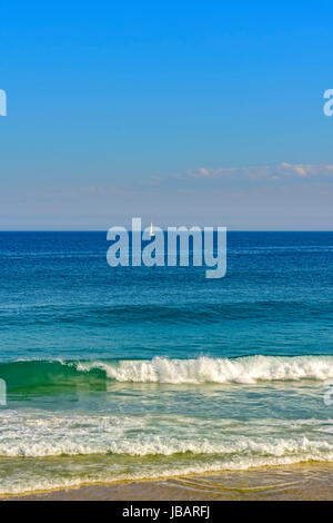 Segelboot segeln am Horizont von den blauen Wassern der Strand von Ipanema in Rio De Janeiro Stockfoto