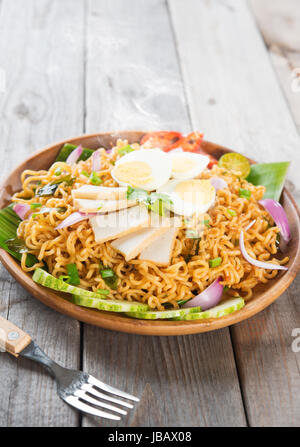 Scharfes Curry getrocknete instant-Nudeln oder malaysischen Stil Maggi Goreng Mamak.  Asiatische Küche, Esstisch aus Holz Einstellung servierfertig. Frisch heiß mit gedünstetem Rauch. Stockfoto