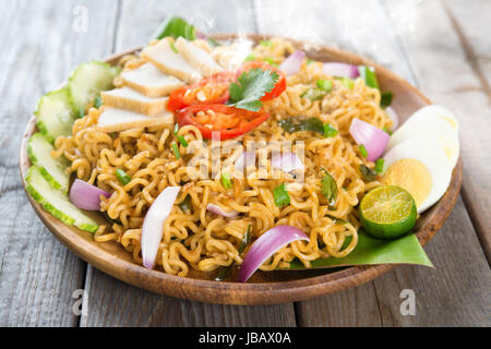 Malaysischen Stil Maggi Goreng Mamak oder würzig gebratene Curry-instant-Nudeln.  Asiatische Küche, Esstisch aus Holz Einstellung servierfertig. Frisch heiß mit gedünstetem Rauch. Stockfoto