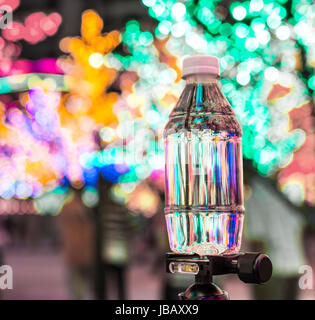 Kleine Plastikflasche Wasser mit Bokeh Hintergrund Stockfoto