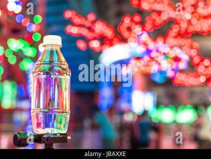 Kleine Plastikflasche Wasser mit Bokeh Hintergrund Stockfoto