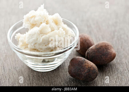 Shea-Nüssen und Sheabutter in Glas Schüssel Stockfoto