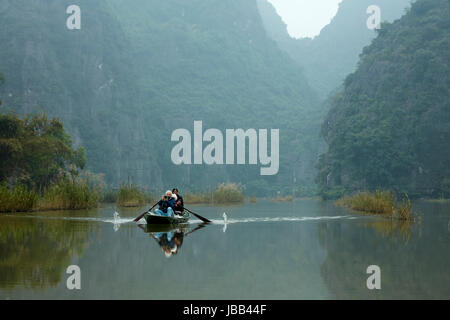 Touristen auf Tam Coc (drei Höhlen) Boot Reise auf Ngo Dong Fluss, (UNESCO World Herritage Area), in der Nähe von Ninh Binh, Vietnam Stockfoto