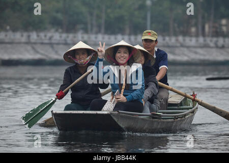 Touristen auf Tam Coc (drei Höhlen) Boot Reise auf Ngo Dong Fluss, (UNESCO World Herritage Area), in der Nähe von Ninh Binh, Vietnam Stockfoto