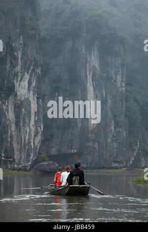 Touristen auf Tam Coc (drei Höhlen) Boot Reise auf Ngo Dong Fluss, (UNESCO World Herritage Area), in der Nähe von Ninh Binh, Vietnam Stockfoto