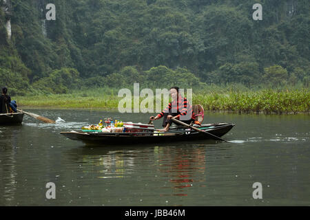 Hawker mit schwimmenden Shop auf Tam Coc (drei Höhlen) Bootsfahrt durch Kalkstein Karst auf Ngo Dong Fluss, (UNESCO World Herritage Area), in der Nähe von Ninh Binh Stockfoto