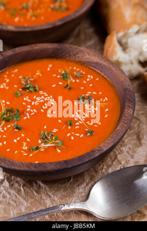 Tomaten Suppe pürieren in Holzschale auf zerkleinerte braune Papiertüte Stockfoto