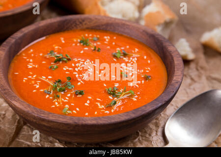 Tomaten Suppe pürieren in Holzschale auf zerkleinerte braune Papiertüte Stockfoto