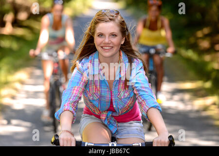 Teenager-Mädchen Reiten Fahrrad mit Freunden Landschaft unterwegs Stockfoto