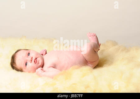 Ein Kleines Neugeborenes Baby Liegt Auf Einem Schaffell. Stockfoto