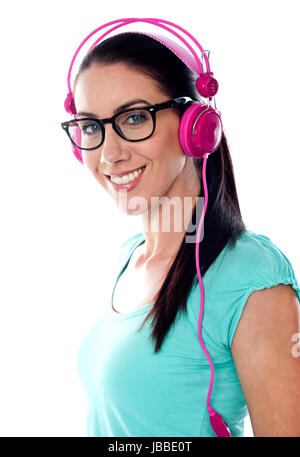 Hübsches Mädchen eingestimmt, hören von Musik über Kopfhörer isoliert auf weißem Hintergrund Stockfoto