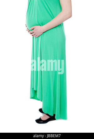 Schwangere Frau erwartet Baby tragen grüne Kleid. Mode-outfit Stockfoto