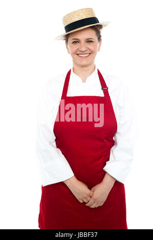 Im Alter von Köchin tragen Hut lächelnd Mitte und in weißer und roter uniform gekleidet Stockfoto