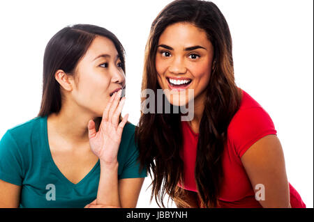 Zwei junge Mädchen tratschen. Asiatin Geheimnis mit ihrer Freundin teilen Stockfoto