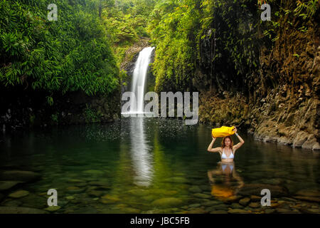 Junge Frau zu Fuß durch Lagune mit einem trockenen Tasche am Wainibau Wasserfall auf Taveuni Island, Fidschi. Taveuni ist die drittgrößte Insel in Fidschi. Stockfoto