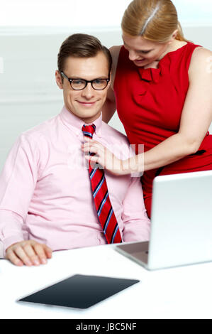 Weiblich, die Anpassung ihrer Mitarbeiterinnen und Mitarbeiter zu binden, im Büro Stockfoto