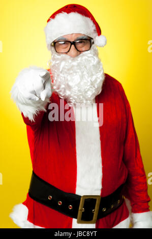 Jelly Belly Santa in Brille auf Sie gerichtet. Isoliert auf gelb. Stockfoto