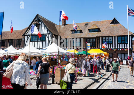 Französischen Markt Veranstaltung außerhalb des 15. Jahrhunderts guildhall in der englischen Stadt, Sandwich. Französische und britische Fahnen, Marktständen, und die Menschen im hellen Sonnenschein. Stockfoto