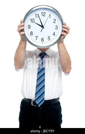 Chef hält eine Uhr vor seinem Gesicht. Mach dich bereit für das Treffen in fünf Minuten! Stockfoto