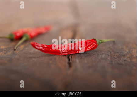 trockene rote Chilischoten über alten Holztisch Stockfoto