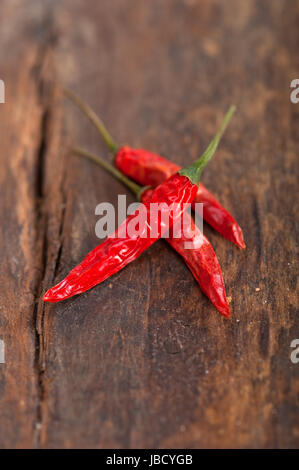 trockene rote Chilischoten über alten Holztisch Stockfoto