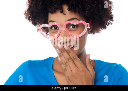 Bild von einer jungen Frau mit herzförmigen Rahmen ihr Kichern zu ersticken beschnitten Stockfoto