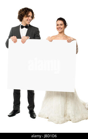 Brautpaar im feinen Hochzeit Aussteuer ein leeres Whiteboard anzeigen Stockfoto