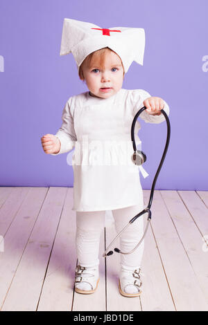 kleines Mädchen spielt in der Krankenschwester Stockfoto