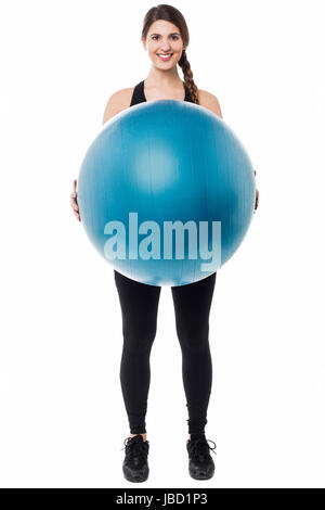 Aktive weibliche Gymnastikausbilder anzeigen einen Swiss Ball. Stockfoto