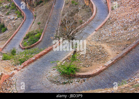 Kurvenreiche Straße führt zu Nahargarh Fort in Jaipur, Rajasthan, Indien. Die Festung wurde als Rückzugsort auf dem Gipfel des dem Bergrücken oberhalb th gebaut. Stockfoto