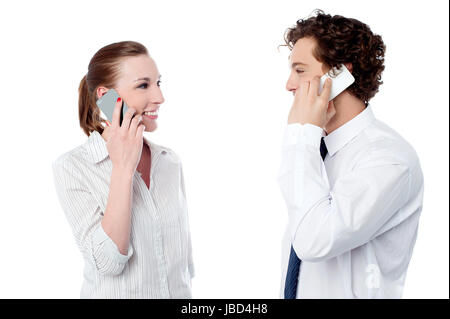 Junge Bürokollegen über Handy kommunizieren Stockfoto