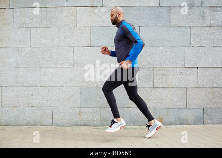 Seitenansicht des laufenden Jüngling im urbanen Umfeld Stockfoto