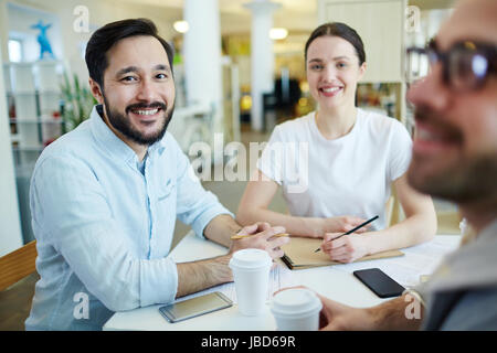 Junge team sitzen am Arbeitsplatz und brainstorming Stockfoto