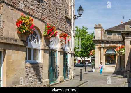 Das Rathaus in Brunnen auf dem gepflasterten Marktplatz steht und fällt im reizvoll Blumenschmuck im Sommer, Somerset, England, UK Stockfoto