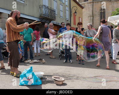 Ein Showman macht und bläst massive Bläschen zur Unterhaltung der Kinder an einem Wochenende fair in Mirepoix, Languedoc, Frankreich Stockfoto