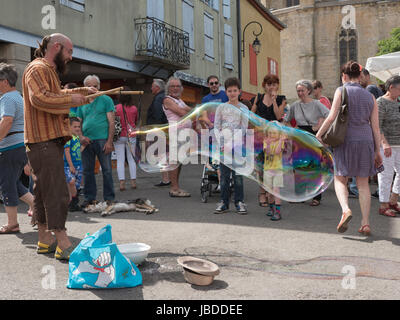 Ein Showman macht und bläst massive Bläschen zur Unterhaltung der Kinder an einem Wochenende fair in Mirepoix, Languedoc, Frankreich Stockfoto