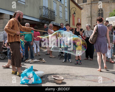 Ein Showman macht und bläst massive Bläschen zur Unterhaltung der Kinder an einem Wochenende fair in Mirepoix, Languedoc, Frankreich Stockfoto