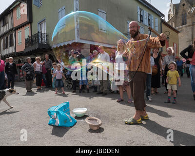 Ein Showman macht und bläst massive Bläschen zur Unterhaltung der Kinder an einem Wochenende fair in Mirepoix, Languedoc, Frankreich Stockfoto