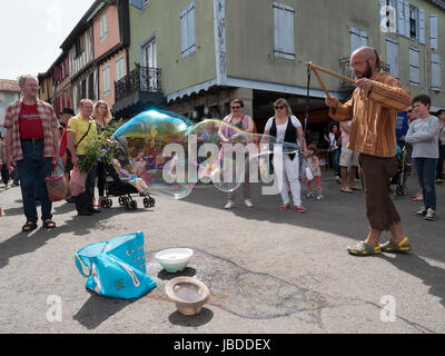 Ein Showman macht und bläst massive Bläschen zur Unterhaltung der Kinder an einem Wochenende fair in Mirepoix, Languedoc, Frankreich Stockfoto