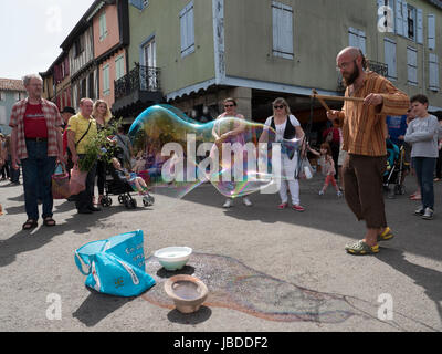 Ein Showman macht und bläst massive Bläschen zur Unterhaltung der Kinder an einem Wochenende fair in Mirepoix, Languedoc, Frankreich Stockfoto