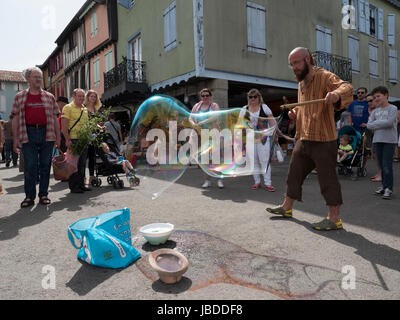 Ein Showman macht und bläst massive Bläschen zur Unterhaltung der Kinder an einem Wochenende fair in Mirepoix, Languedoc, Frankreich Stockfoto