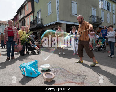 Ein Showman macht und bläst massive Bläschen zur Unterhaltung der Kinder an einem Wochenende fair in Mirepoix, Languedoc, Frankreich Stockfoto