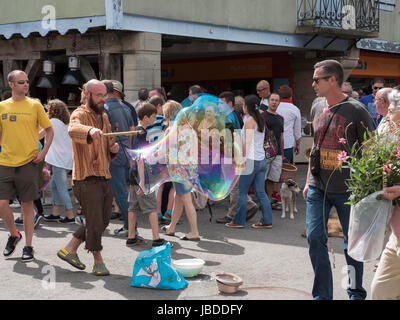 Ein Showman macht und bläst massive Bläschen zur Unterhaltung der Kinder an einem Wochenende fair in Mirepoix, Languedoc, Frankreich Stockfoto