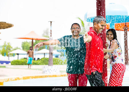 Happy indischen Eltern und Tochter rotierende Pole Baden Waterpark genießen Sie lächelnd Stockfoto