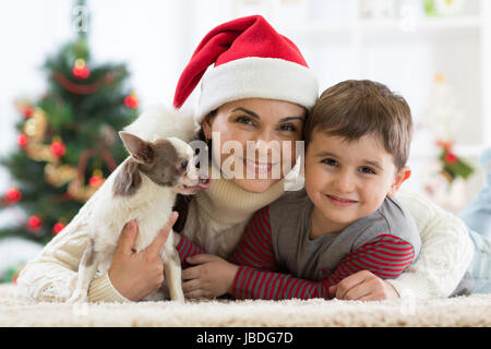 Porträt einer glücklichen Familie und der Hund zusammen Weihnachtszeit zu Hause in der Nähe der x-mas-Baum Stockfoto