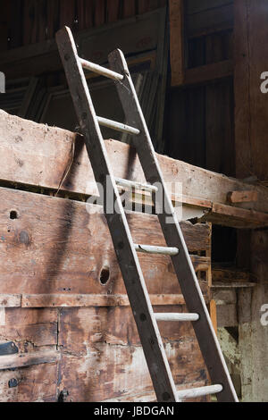 Antike Holzleiter in verlassenen alten Scheune. Stockfoto